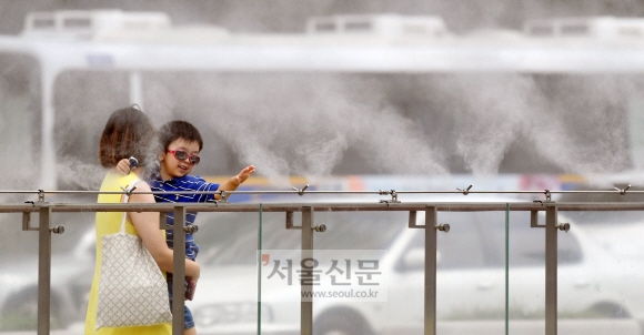 1일 서울 세종대로 광화문광장에 쿨링포그 시스템을 적용해 설치된 쿨 스팟(Cool Spot)에서 한 어린이가 더위를 식히고 있다. 정연호 기자 tpgod@seoul.co.kr