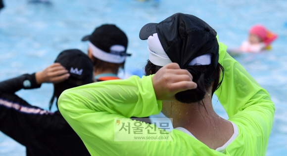 1일 서울의 한 한강 수영장에서 이용객들이 수영모를 착용한 채 야구모자를 쓰고 있다. 한강수영장에서는 수영모를 착용하지 않으면 물 안에 들어갈 수 없다. 박윤슬 기자 seul@seoul.co.kr