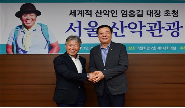 이성희 서울시의회 문화체육관광위원장(오른쪽)이 7월31일 서울시의회에서 열린 산악관광 활성화 간담회에 참석한 산악인 엄홍길 대장과 악수를 나누고 있다.