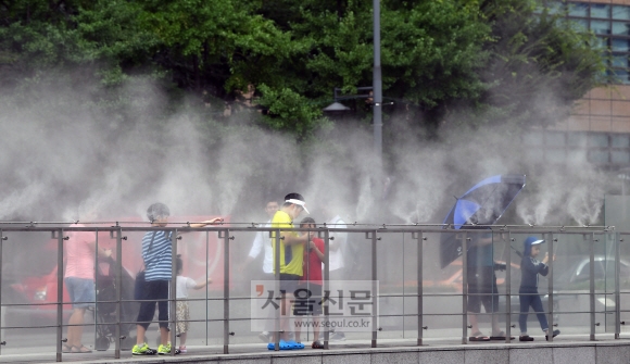 전국 대부분 지역에 폭염특보가 발효된 2일 서울 중구 광화문광장을 지나는 시민들이 광장에 설치된 분무기에서 뿜어져 나오는 물안개를 맞으며 더위를 식히고 있다.  강성남 선임기자 snk@seoul.co.kr