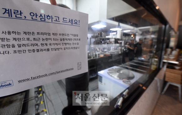16일 서울 강남의 한 음식점에서 종업원이 살충제 계란을 사용하지 않는다는 문구가 적힌 안내문을 붙이고 있다.  정연호 기자 tpgod@seoul.co.kr