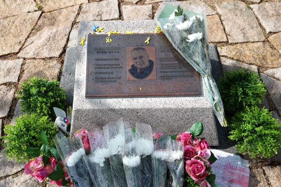 20일 영화 ‘택시운전사’의 실제 모델인 독일 언론인 위르겐 힌츠페터의 광주 북구 망월동 옛 5·18 묘역 추모비 주변에 추도객들이 놓고 간 꽃과 편지가 쌓여 있다. 광주 연합뉴스