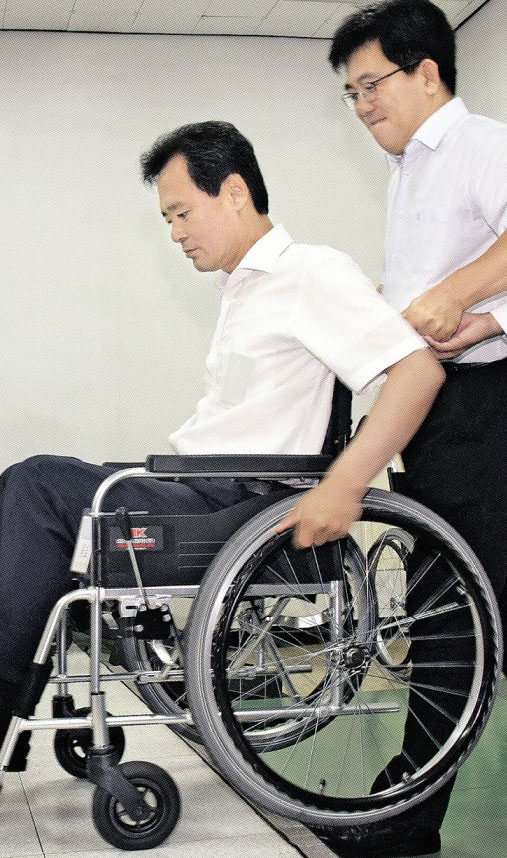 박겸수(왼쪽) 서울 강북구청장이 지난 17일 강북구 인수동에 위치한 국립재활원에서 직접 수동휠체어를 타며 장애인의 생활을 체험해 보고 있다. 최해국 선임기자 seaworld@seoul.co.kr