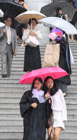 23일 서울 종로구 상명대학교에서 후기 졸업식에 참가한 졸업생들이 우산들 들고 졸업식장을 나서고 있다. 2017.8.23 도준석 기자 pado@seoul.co.kr