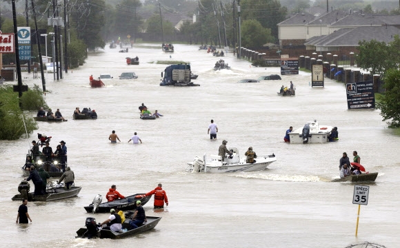 초강력 허리케인 ‘하비’가 미국 텍사스주를 강타한 가운데 28일(현지시간) 물에 잠긴 휴스턴에서 구조원과 구조 보트들이 주민들을 구조하고 있다. AP 연합뉴스