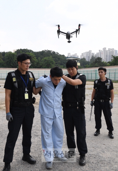 경기 안양시 동안구 안양교도소에서 31일 교도관들이 카메라가 장착된 무인비행장치(드론)를 이용해 탈옥수를 체포하는 장면을 연출하고 있다. 이호정 전문기자 hojeong@seoul.co.kr