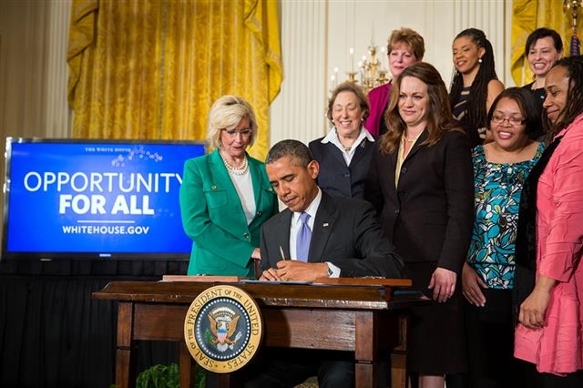 버락 오바마 전 미국 대통령이 2014년 4월 8일 ‘동일임금의 날’을 맞아 백악관 이스트룸에서 여성을 위한 동일임금법 이행 강화를 위한 행정명령에 서명하고 있다. 백악관 제공