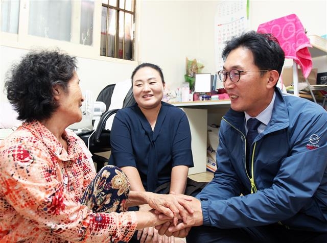 이창우(오른쪽) 동작구청장이 복지플래너와 함께 지난달 29일 서울 동작구에 있는 조손가정인 김모 할머니 집을 방문해 손을 잡고 이야기하고 있다. 동작구 제공