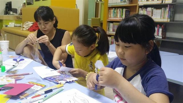 서울 양천구 지양마을 엄마와 아이들이 지양도서관을 찾아 색종이로 만들기 놀이를 하고 있다. 양천구 제공
