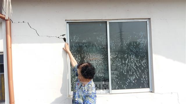 8일 오전 경북 경주시 내남면 부지1리 도정옥씨가 집 외벽의 균열을 가리키며 하소연하고 있다. 그는 지진으로 집이 뒤틀려 문을 제대로 여닫을 수 없을 정도라고 했다.