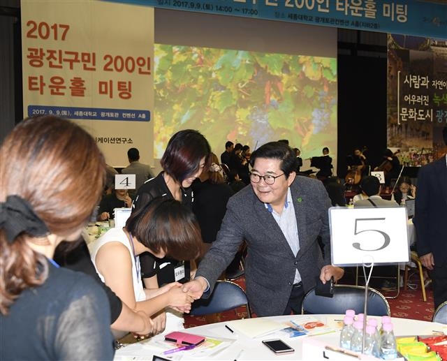 김기동(오른쪽) 서울 광진구청장이 지난 9일 세종대 광개토컨벤션 A홀에서 열린 ‘광진구 타운홀 미팅’에서 테이블을 돌며 구민들의 의견을 듣고 있다. 광진구 제공