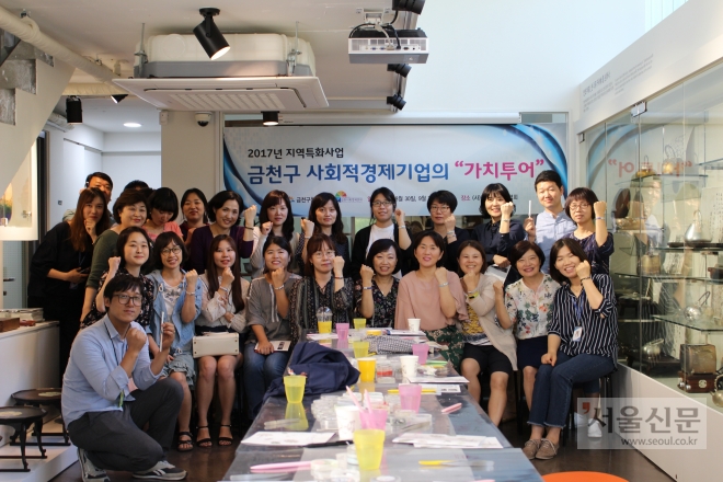 금천구청 물품 구매 담당 직원들이 지역 사회적기업을 방문해 제품 생산 현장을 둘러보고 파이팅을 하며 기념사진을 찍고 있다. 금천구 제공