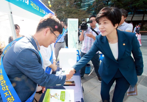 김영주(오른쪽) 고용노동부 장관이 18일 서울 구로디지털단지역에 설치된 현장노동청을 찾아 관계자들과 악수하고 있다. 연합뉴스