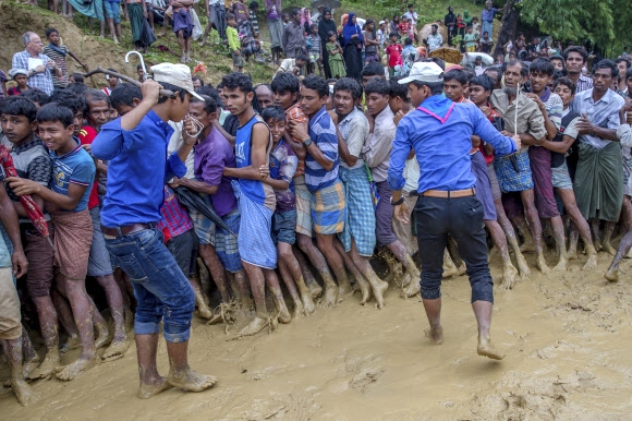 19일 방글라데시 쿠투팔롱 난민캠프에서 방글라데시인들이 배식을 기다리는 로힝야족 난민들을 쇠갈고리로 위협하며 통제하고 있는 모습. 쿠투팔롱 AP 연합뉴스