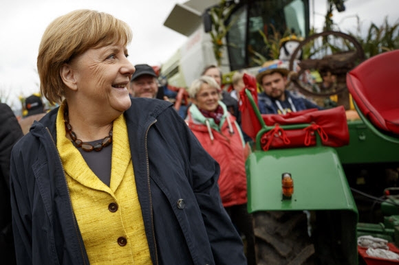 앙겔라 메르켈 독일 총리가 총선을 하루 앞둔 23일(현지시간) 자신의 지역구가 있는 독일 메클렌부르크포어포메른주 푸트부스를 찾아 추수감사축제의 일환으로 열린 트랙터 전시장에서 참가자들을 향해 웃어 보이고 있다. 푸트부스 EPA 연합뉴스