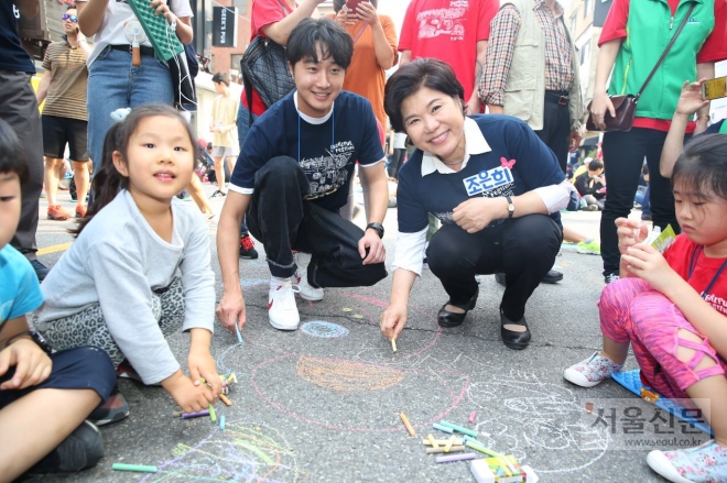 조은희(오른쪽 두 번째) 서초구청장과 배우 정일우(세번째)가 24일 서울 서초구 방배동 카페골목 일대에서 ‘2017 서리풀 페스티벌’의 일환으로 열린 ‘방배카페골목 한마음 축제’에 참석해 아스팔트에 분필로 그림을 그리고 있다. 서초구 제공 