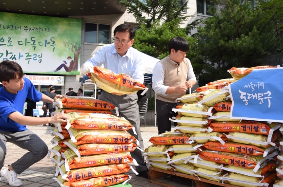 유덕열 동대문구청장이 지난 22일 구청 광장에서 삼육재단으로부터 기증받은 쌀 포대를 불우이웃들에게 전달하기 위해 수레에 싣고 있다. 최해국 선임기자 seaworld@seoul.co.kr