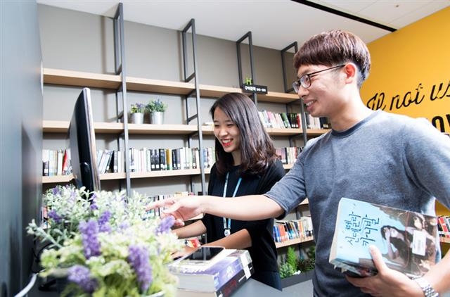 삼성 디지털시티에 설치된 ‘북카페’에서 삼성전자 직원들이 책을 고르고 있다.