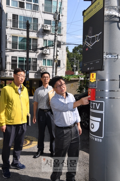 김성환(오른쪽) 노원구청장이 26일 서울 노원구 공릉동의 주택가 골목 전봇대에 마련된 비상벨의 작동 상태를 확인하고 있다. 이호정 전문기자 hojeong@seoul.co.kr