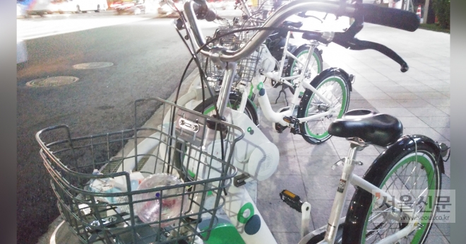 지난 26일 서울시 공공자전거 서울시청 대여소에 세워진 자전거 바구니에 쓰레기가 담겨 있다.