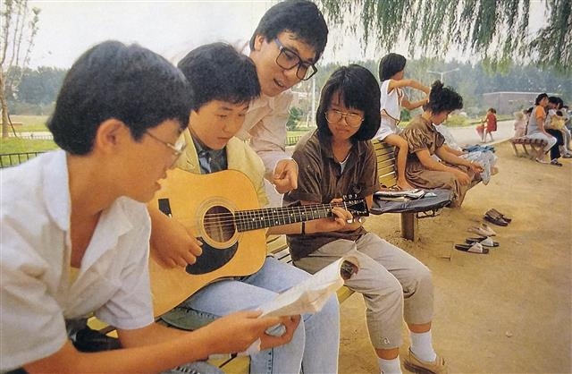 라디오 프로그램 진행자로도 큰 인기를 모으고 있던 가수 이문세를 야외에서 만나 인터뷰했다. 사진은 이문세(왼쪽 세번째)가 공원에서 만난 학생들에게 기타를 가르쳐 주는 모습.