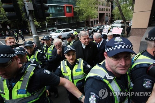 호주의 조지 펠 추기경(가운데 키 큰 이)이 6일 경찰의 보호를 받아가며 멜버른 치안법원에 도착하고 있다.[EPA=연합뉴스]
