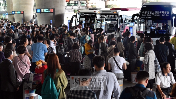 역대 최대의 공항 도착객이 몰린 8일 인천국제공항에서 리무진 버스를 타려는 시민들이 플랫품을 가득 채우고 있다. 2017.10.8  박지환 기자 popocar@seoul.co.kr