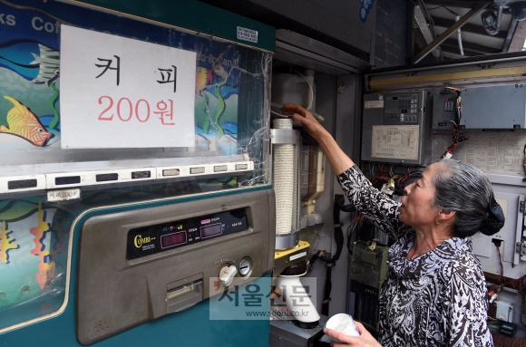 돌아가신 시어머니 커피자판기를 물려받아 2대째 운영하고 있는 고한순(63)씨가 자판기를 청소하고 재료를 보충하고 있다.