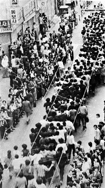 부마항쟁 당시 부산 시내에서 학생과 시민들이 어깨동무를 하고 독재 타도를 외치며 행진하고 있다. 연합뉴스