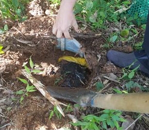 검찰 수사관들이 땅속에 묻힌 돈다발이 든 김치통을 발견하는 모습. 순천지청 제공