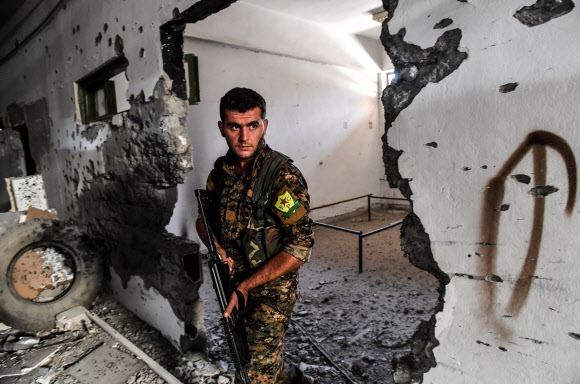 쿠르드·아랍연합군인 시리아민주군(SDF) 병사가 18일(현지시간) 극단주의 무장단체 이슬람국가(IS)가 패퇴한 시리아 락까의 시립 경기장을 순찰하고 있다. 락까 AFP 연합뉴스