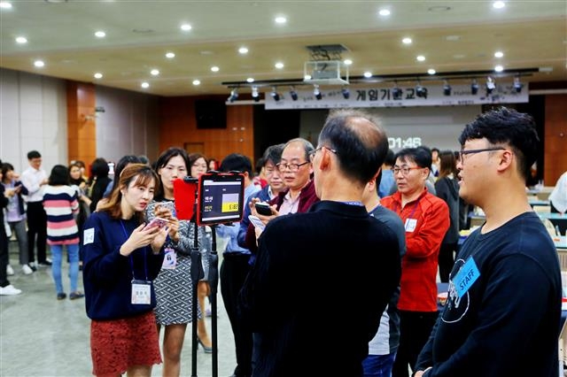 서울 금천구청 직원들이 지난 18일 구청 대강당에 모여 디지털기기를 활용해 게임에 참여하고 있다. 금천구 제공