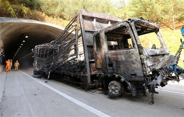 2015년 10월 경북 구미시 중부내륙고속도로 상주터널에서 벽면을 들이받아 폭발해 뼈대만 남은 트럭이 실려가고 있다. 연합뉴스