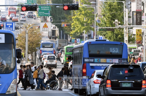 지난 20일 낮 차량이 가득한 서울 마포구의 한 횡단보도를 시민들이 건너고 있다. 강성남 선임기자 snk@seoul.co.kr
