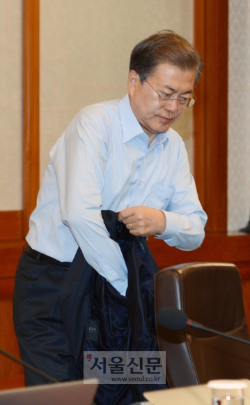24일 청와대 본관에서 열린 국무회의에 참석한 문재인 대통령이 회의시작전 양복 상의를 벗고 있다. 안주영 기자 jya@seoul.co.kr