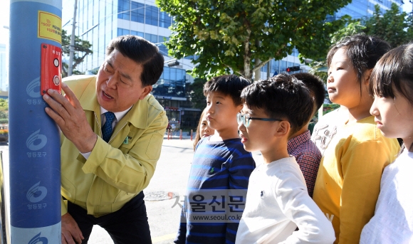 조길형(왼쪽) 서울 영등포구청장이 24일 영등포구 당산동에 위치한 당서초등학교 앞에서 초등학생들과 함께 비상벨이 제대로 작동되는지 시험해 보고 있다. 강성남 선임기자 snk@seoul.co.kr