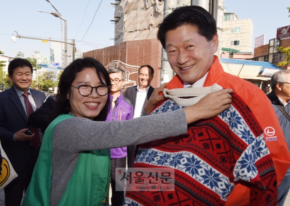 최창식(오른쪽) 서울 중구청장이 지난 23일 광희동2가 광희문 앞에서 열린 ‘신당동 사랑나눔 바자회’에서 판매하는 옷이 어울리는지 보고 있다. 최해국 선임기자 seaworld@seoul.co.kr