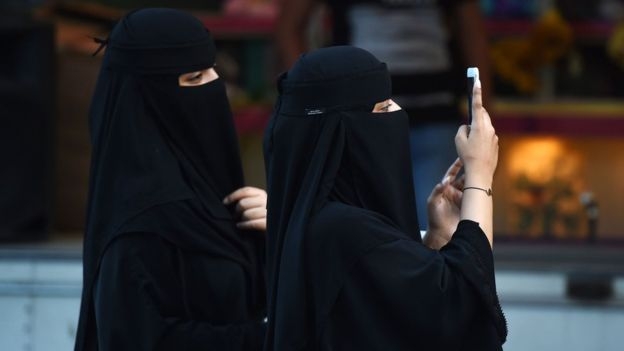 와하비즘을 추종하는 사우디아라비아에서는 남녀 구분이 엄격하다. 수도 리야드의 타흘리야 거리를 거닐며 손전화를 들여다보는 여성들. AFP 연합뉴스