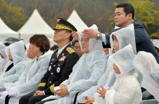 [서울포토] ‘뒤에서 살포시’…문재인 대통령 우비 씌워주는 경호원