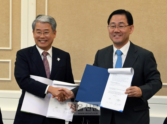 국민의당 김동철(왼쪽) 원내대표와 바른정당 주호영 원내대표가 3일 국회에서 양당의 공동 정책연대를 발표하면서 함께 추진하기로 한 정책안을 든 채 악수를 나누고 있다. 강성남 선임기자 snk@seoul.co.kr