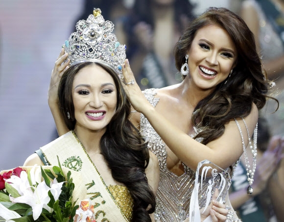 4일(현지시간) 필리핀 파사이시티의 아시아 아레나 몰에서 열린 ‘2017 미스 어스 선발대회(Miss Earth 2017 beauty contest)’에서 우승을 차지한 필리핀의 카렌 이바스코(왼쪽)가 전년도 우승자인 케서린 에스핀에게 왕관을 물려받고 있다. EPA 연합뉴스