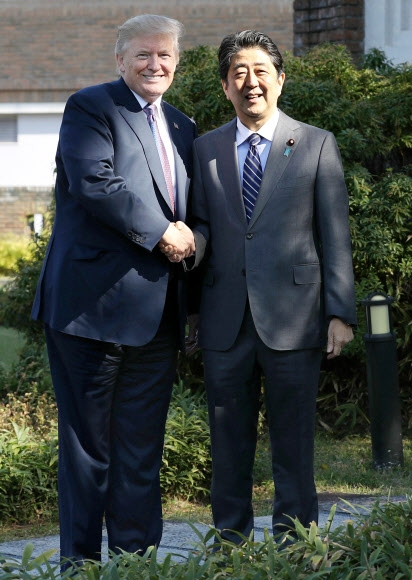 도널드 트럼프 미국 대통령(왼쪽)과 아베 신조 일본 총리가 5일 사이타마현 가스미가세키CC에서 골프 라운딩에 앞서 악수하고 있다. 2017-11-05 연합뉴스