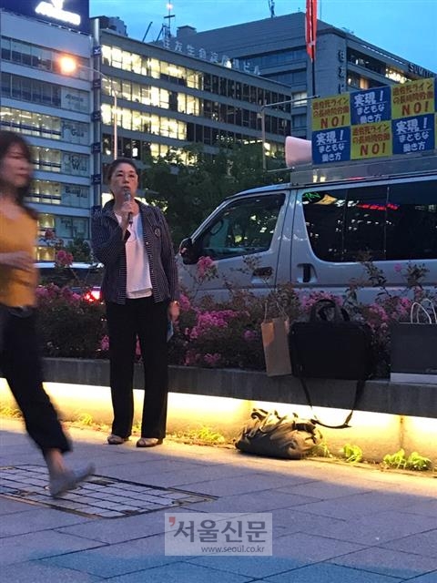 데라니시 에미코 전국 과로사를 생각하는 가족 모임 대표가 일본 오사카의 한 지하철역 앞에서 퇴근하는 직장인들을 상대로 과로 예방 캠페인을 벌이고 있다. 오사카 유대근 기자 dynamic@seoul.co.kr