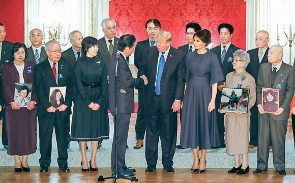 도널드 트럼프(앞줄 오른쪽 네 번째) 미국 대통령과 부인 멜라니아(오른쪽 세 번째)가 6일 도쿄 아카사카 영빈관에서 일본인 납북 피해자 가족 17명과 만난 뒤 아베 신조(왼쪽 네 번째) 일본 총리와 악수하고 있다. 트럼프 대통령은 “북한에 납치된 피해자들이 귀국해 가족들 품에 돌아올 수 있도록 아베 총리와 긴밀히 협력해 가겠다”고 말했다. 아베 총리 왼쪽은 부인 아키에. 도쿄 EPA 연합뉴스
