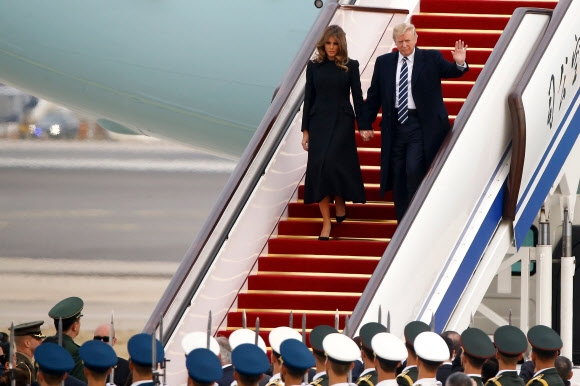 도널드 트럼프(오른쪽) 미국 대통령이 부인 멜라니아의 손을 잡고 8일 베이징 서우두 국제공항에서 빨간색 카펫이 깔린 계단을 통해 에어포스원에서 내리고 있다. 서울신문 포토라이브러리
