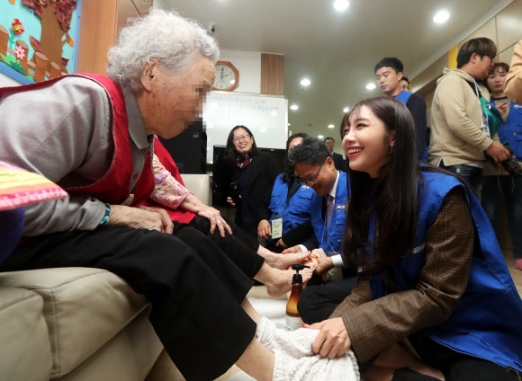 13일 오후 경기도 군포시 매화종합사회복지관에서 진행된 복권위원회 제10기 행복공감봉사단 봉사활동에서 복권위원회 홍보대사 에이핑크 정은지가 어르신에게 발 마사지를 해주며 환하게 웃고 있다. <br>연합뉴스