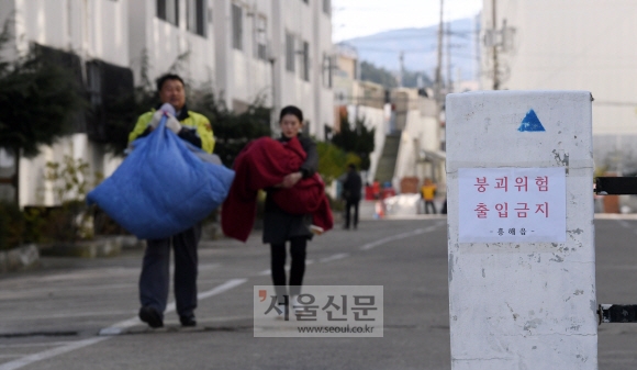 16일 포항시 흥해읍의 한 아파트가 지진으로 인해 기울어져 주민대피령이 내려진 가운데 주민들이 물품을 챙겨서 나오고 있다. 2017. 11. 16  정연호 기자 tpgod@seoul.co.kr
