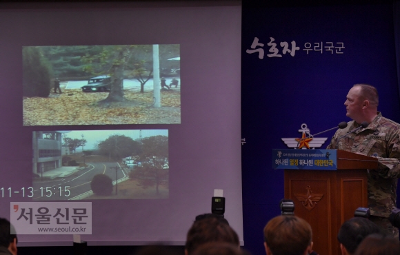 채드 캐럴 유엔군사령부 대변인이 22일 국방부 브리핑실에서 지난 13일 판문점 공동경비구역(JSA)을 넘어 귀순한 북한 병사의 당시 총격 상황이 담긴 폐쇄회로(CC)TV 영상을 공개하며 상황을 설명하고 있다.  이호정 전문기자 hpjeong@seoul.co.kr