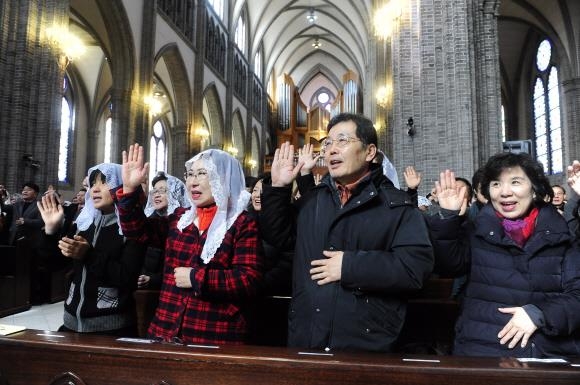 지난 19일 서울 중구 명동성당에서 열린 ‘한국 평신도 희년’ 선포 미사에 참여한 천주교 신자들이 손을 들고 희년 동안 더욱 그리스도인답게 살 것을 다짐하고 있다. 천주교 서울대교구 제공