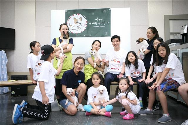이해식(뒷줄 오른쪽 다섯 번째) 구청장이 지난 8월 ‘포근하개 봉사단’과 함께 경기 남양주에 위치한 반려동물복지센터에서 봉사활동을 펼친 뒤 사진 촬영을 하고 있다. 강동구 제공